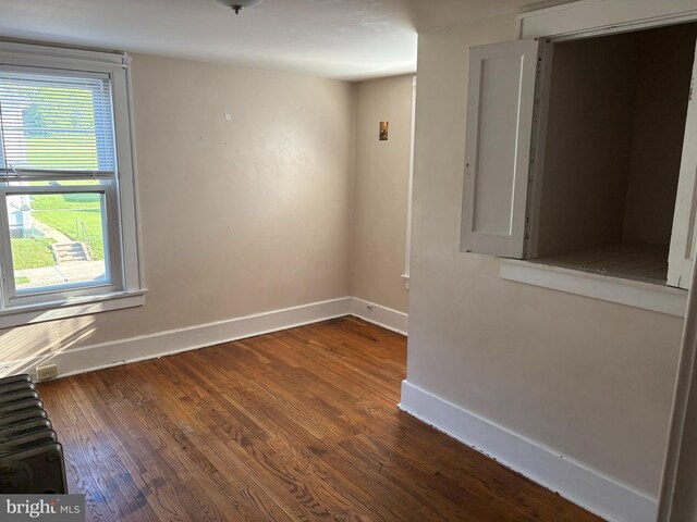 empty room with baseboards and wood finished floors