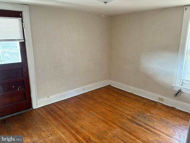 empty room with hardwood / wood-style floors and baseboards