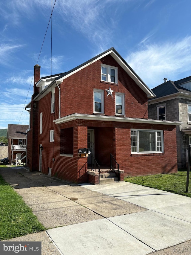 rear view of property with brick siding and a chimney
