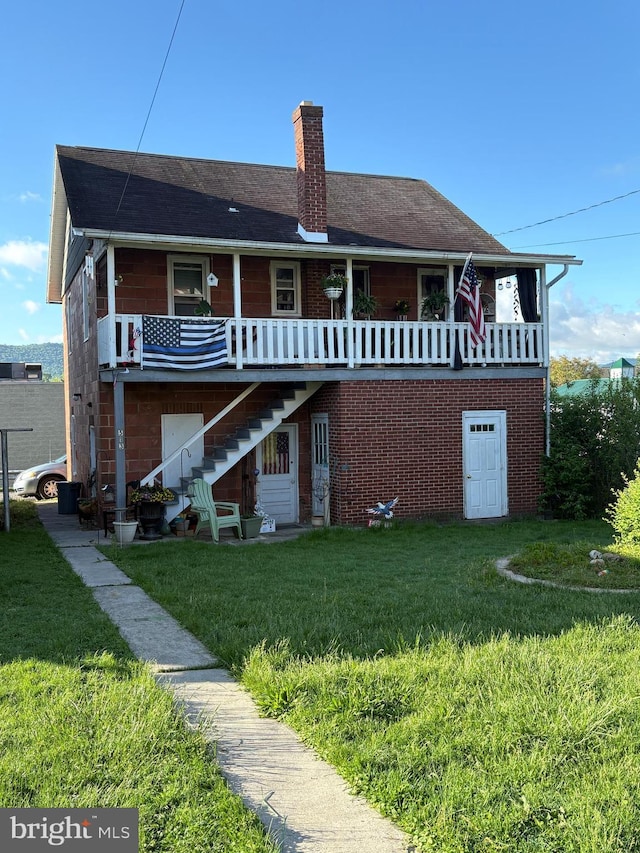 back of house with a chimney, a yard, and stairway