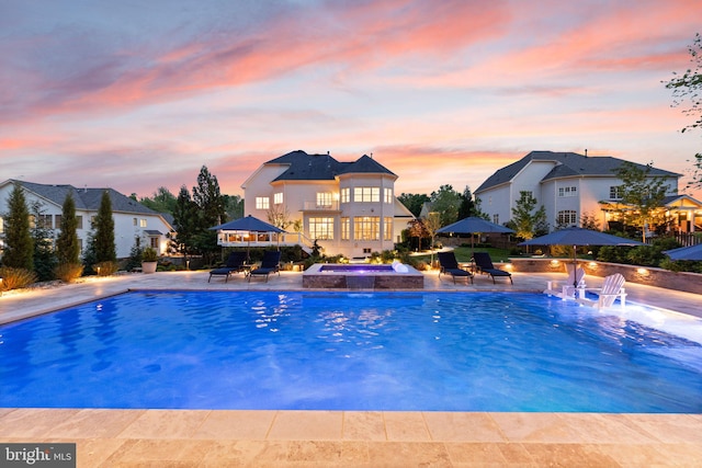 18729 Upper Meadow Dr, Leesburg, VA 20176 - pool at dusk with a patio area, fence, and a pool with connected hot tub