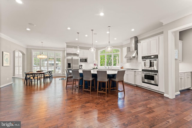 18729 Upper Meadow Dr, Leesburg, VA 20176 - kitchen featuring built in appliances, wall chimney range hood, dark wood-style floors, tasteful backsplash, and recessed lighting