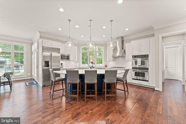 18729 Upper Meadow Dr, Leesburg, VA 20176 - kitchen featuring built in appliances, wall chimney range hood, light countertops, white cabinetry, and crown molding