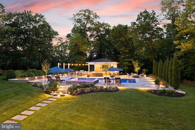 18729 Upper Meadow Dr, Leesburg, VA 20176 - pool at dusk featuring a yard, a patio area, an outdoor pool, an outdoor living space, and an outdoor hot tub
