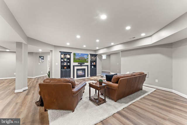 18729 Upper Meadow Dr, Leesburg, VA 20176 - living area with wood finished floors, baseboards, recessed lighting, and a glass covered fireplace
