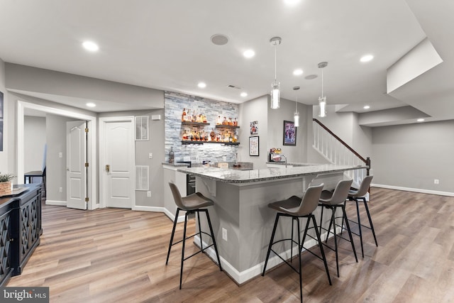 18729 Upper Meadow Dr, Leesburg, VA 20176 - kitchen with a breakfast bar, light wood-type flooring, light stone countertops, decorative light fixtures, and recessed lighting