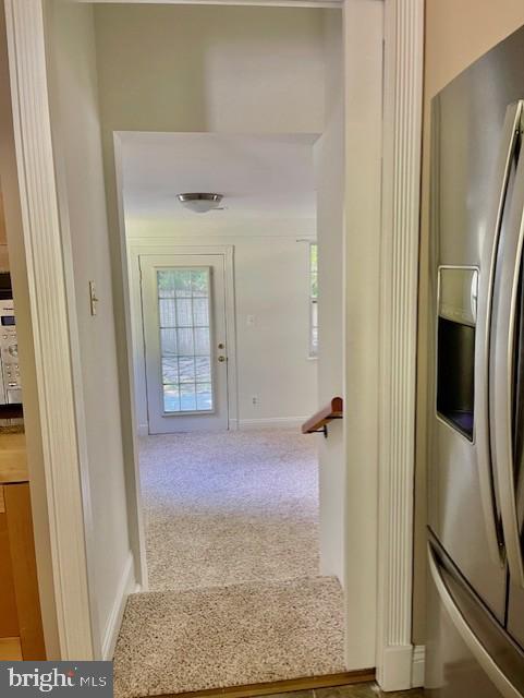 hallway with carpet floors and baseboards