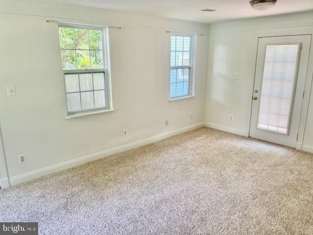 unfurnished room with light carpet and baseboards