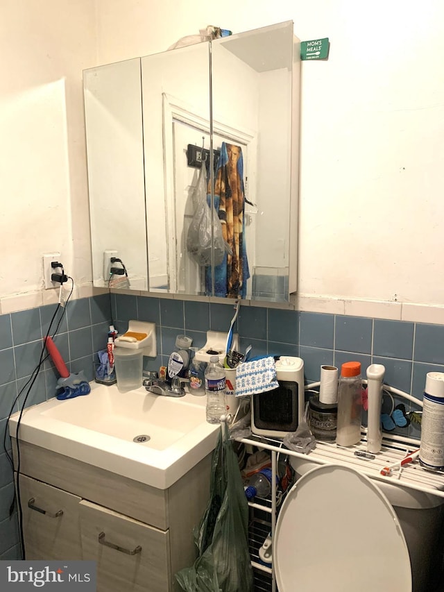 bathroom featuring tile walls, tasteful backsplash, and vanity