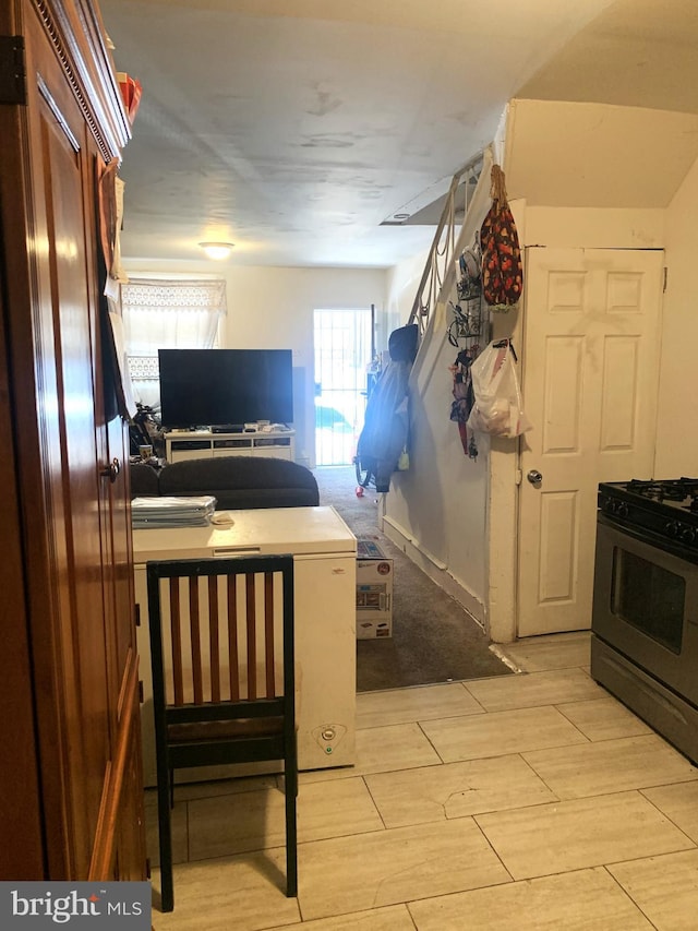 kitchen featuring gas range oven, open floor plan, and light wood finished floors