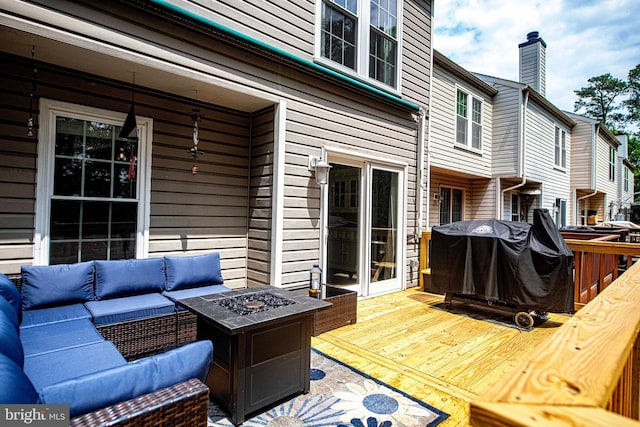 wooden deck with an outdoor living space with a fire pit
