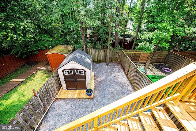 deck featuring a storage shed, an outdoor structure, and a fenced backyard