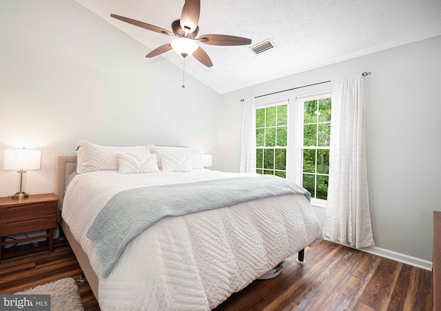 bedroom featuring lofted ceiling, wood finished floors, baseboards, a textured ceiling, and a ceiling fan
