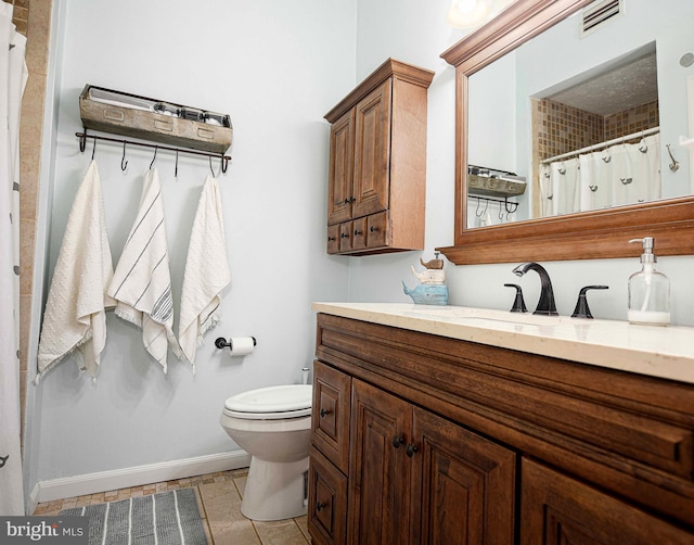 bathroom with baseboards, toilet, vanity, stone tile floors, and a shower with shower curtain