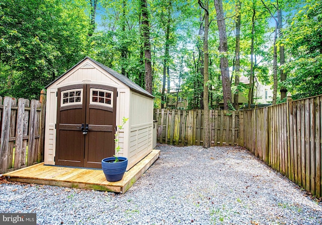 view of shed with a fenced backyard and view of scattered trees