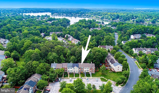 aerial view of property and surrounding area with a large body of water and nearby suburban area