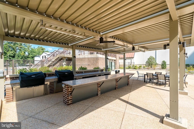 view of patio / terrace featuring an outdoor kitchen, a grill, outdoor dining area, and stairs