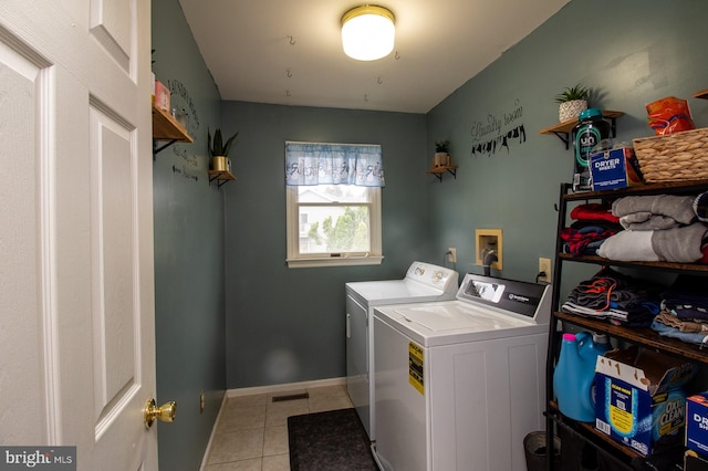 laundry area with washer and clothes dryer, light tile patterned floors, and baseboards