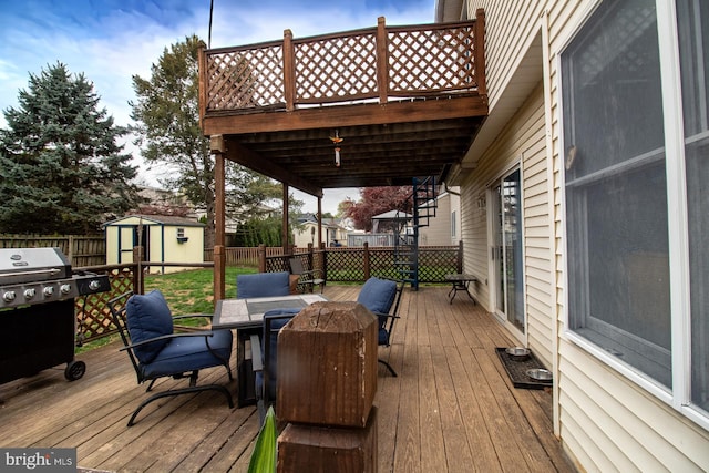 deck with outdoor dining area, a shed, a fenced backyard, an outbuilding, and grilling area