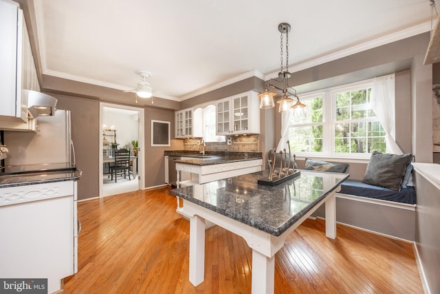 154 Plowshare Rd, Eagleville, PA 19403 - kitchen with light wood-type flooring, a breakfast bar, white cabinetry, glass insert cabinets, and ornamental molding