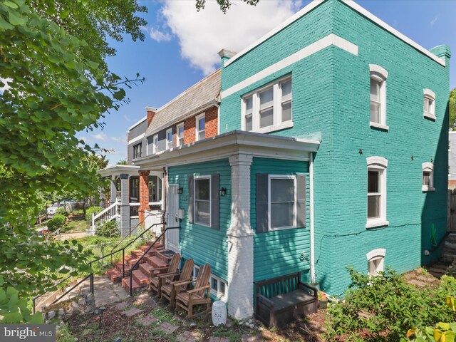 back of property featuring brick siding