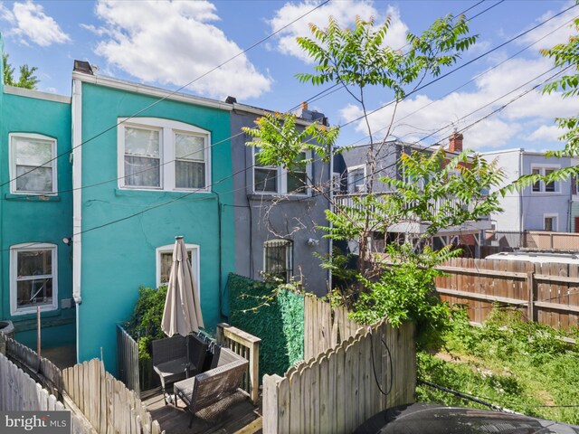 rear view of house with fence and stucco siding