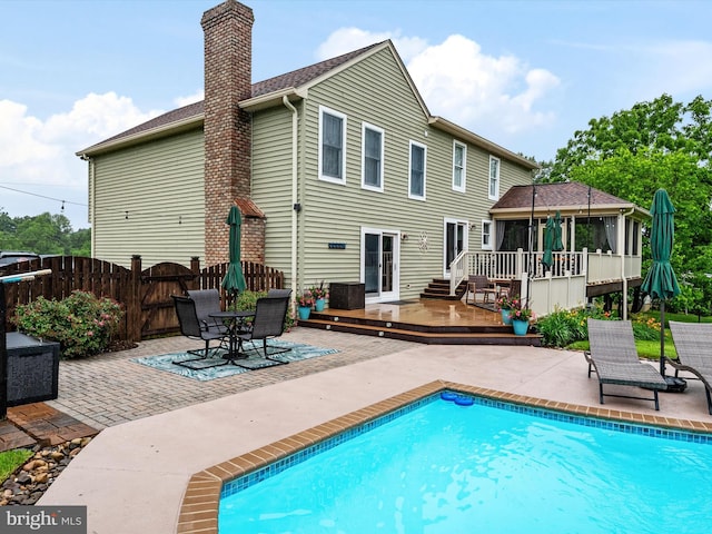 6085 Franklin Gibson Rd, Tracys Landing, MD 20779 - rear view of property featuring a deck, a patio area, a chimney, a sunroom, and a gazebo