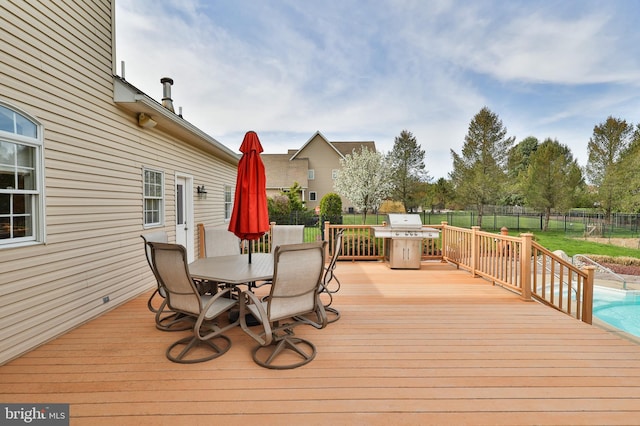 wooden deck with a fenced backyard, outdoor dining space, and a grill