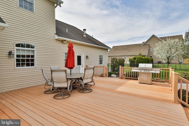 deck with outdoor dining area, area for grilling, and fence