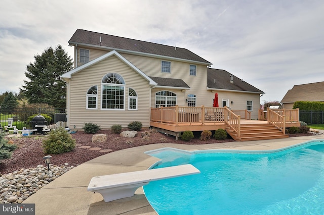 rear view of house with a wooden deck, fence, and a patio area