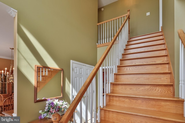 staircase featuring a chandelier and a high ceiling