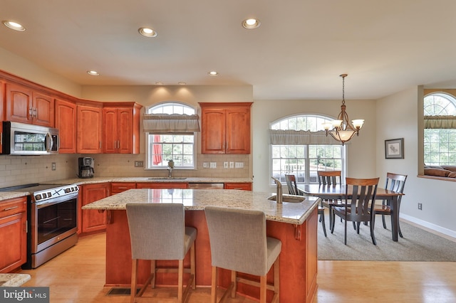 kitchen featuring appliances with stainless steel finishes, a chandelier, a sink, recessed lighting, and light wood-type flooring