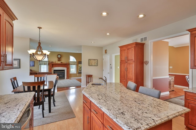 kitchen featuring a sink, open floor plan, light wood-style floors, and recessed lighting