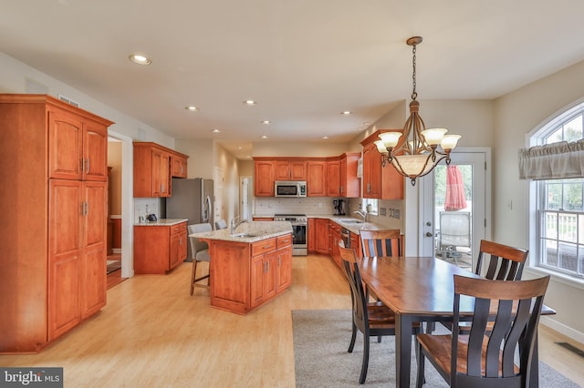 dining space featuring light wood-type flooring, a chandelier, and recessed lighting