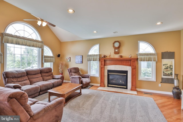 living room with plenty of natural light, a ceiling fan, a fireplace, light wood-style floors, and recessed lighting