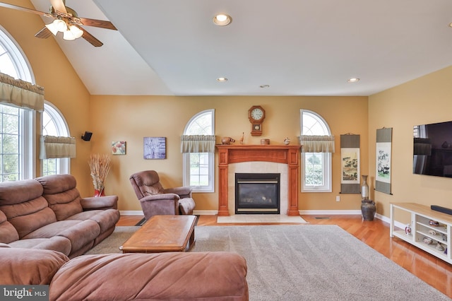 living room featuring healthy amount of natural light, a tiled fireplace, light wood finished floors, recessed lighting, and ceiling fan