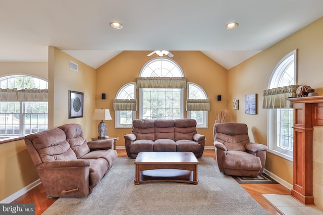 living area with plenty of natural light, baseboards, vaulted ceiling, wood finished floors, and recessed lighting