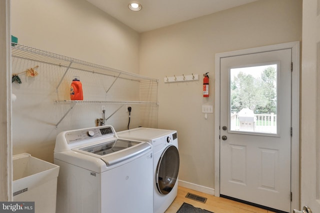 laundry room with washer and dryer, light wood finished floors, baseboards, and recessed lighting