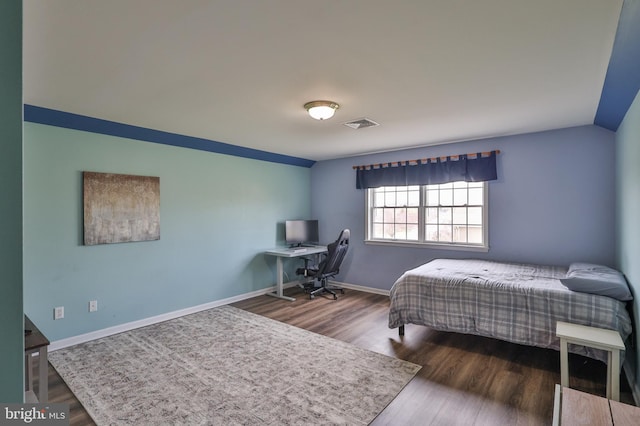 bedroom featuring wood finished floors, an office area, and baseboards