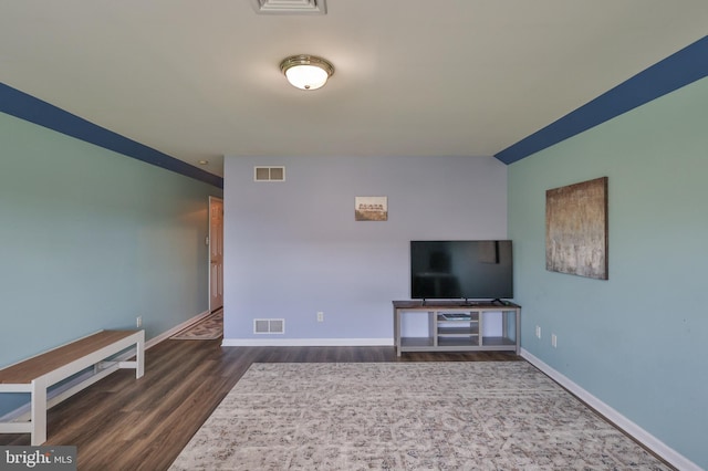 unfurnished living room featuring wood finished floors and baseboards