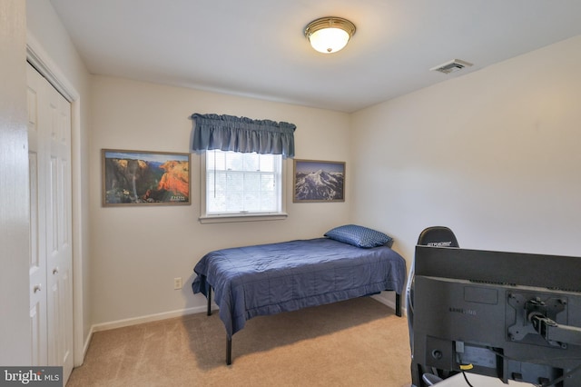 carpeted bedroom with baseboards and a closet