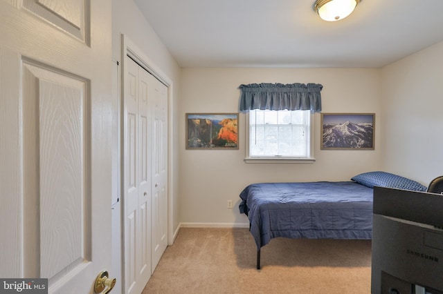 bedroom with carpet flooring, baseboards, and a closet