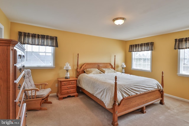 bedroom with light carpet and baseboards