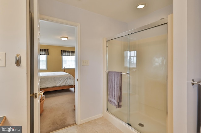 bathroom featuring baseboards, a shower stall, and connected bathroom