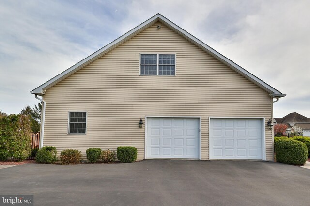 view of property exterior featuring driveway and a garage