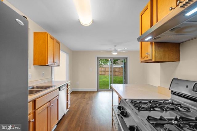 kitchen featuring stainless steel appliances, under cabinet range hood, dark wood-type flooring, light countertops, and a ceiling fan