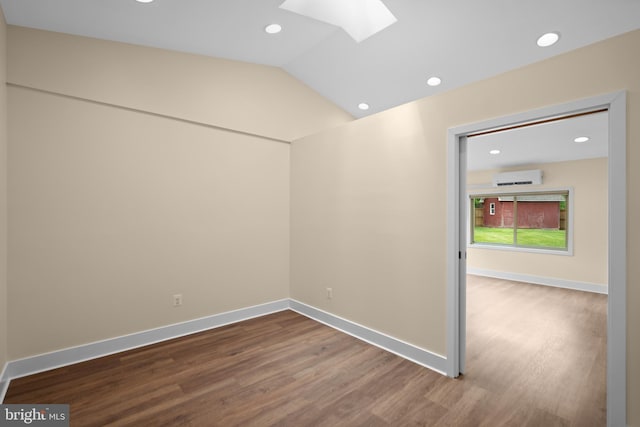 empty room featuring a skylight, dark wood finished floors, recessed lighting, baseboards, and a wall mounted air conditioner