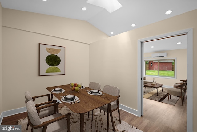 dining area with a skylight, a wall mounted air conditioner, recessed lighting, wood finished floors, and vaulted ceiling