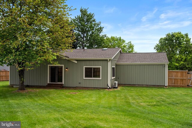 rear view of property featuring entry steps and roof with shingles
