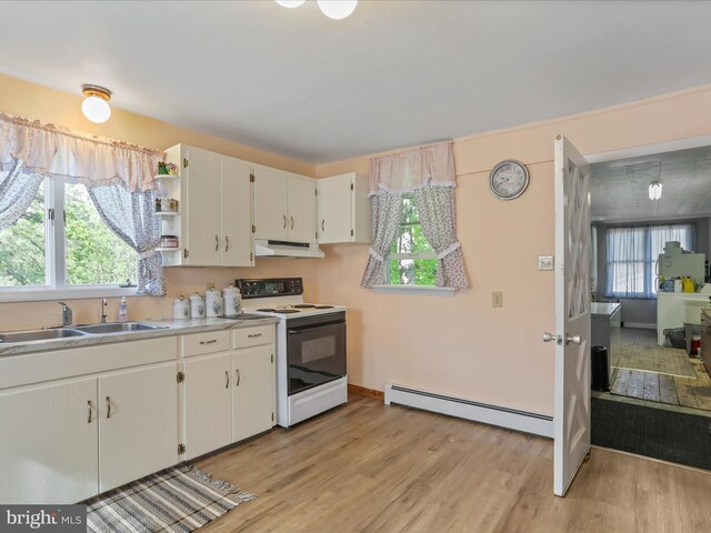 4126 Coseytown Rd, Greencastle, PA 17225 - kitchen with electric range, a baseboard heating unit, a sink, under cabinet range hood, and light wood-style flooring